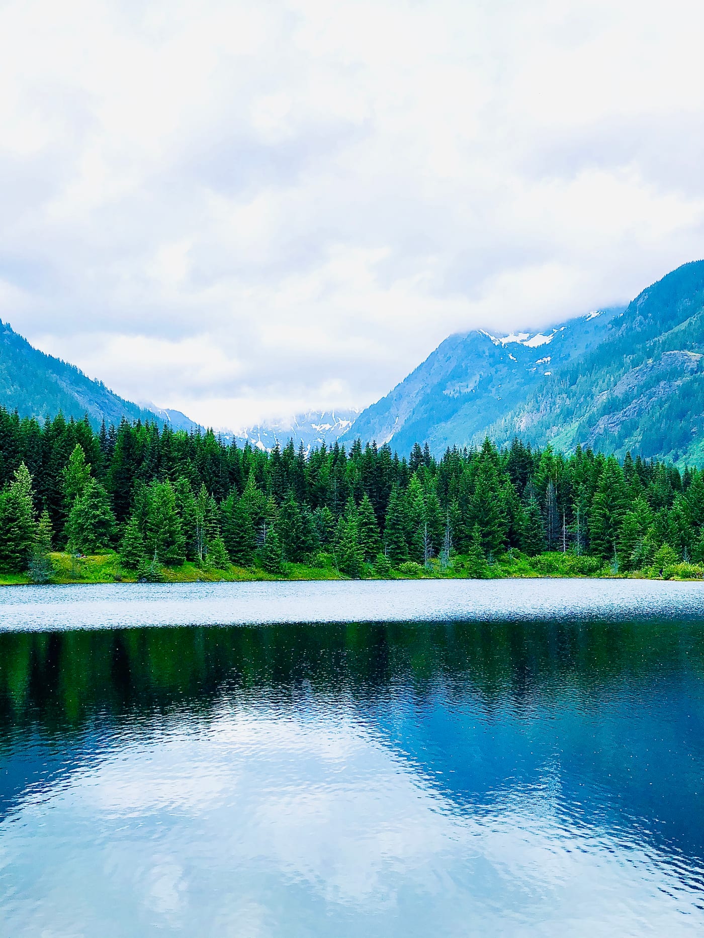 Blue mountain lake ringed by evergreen slopes.
