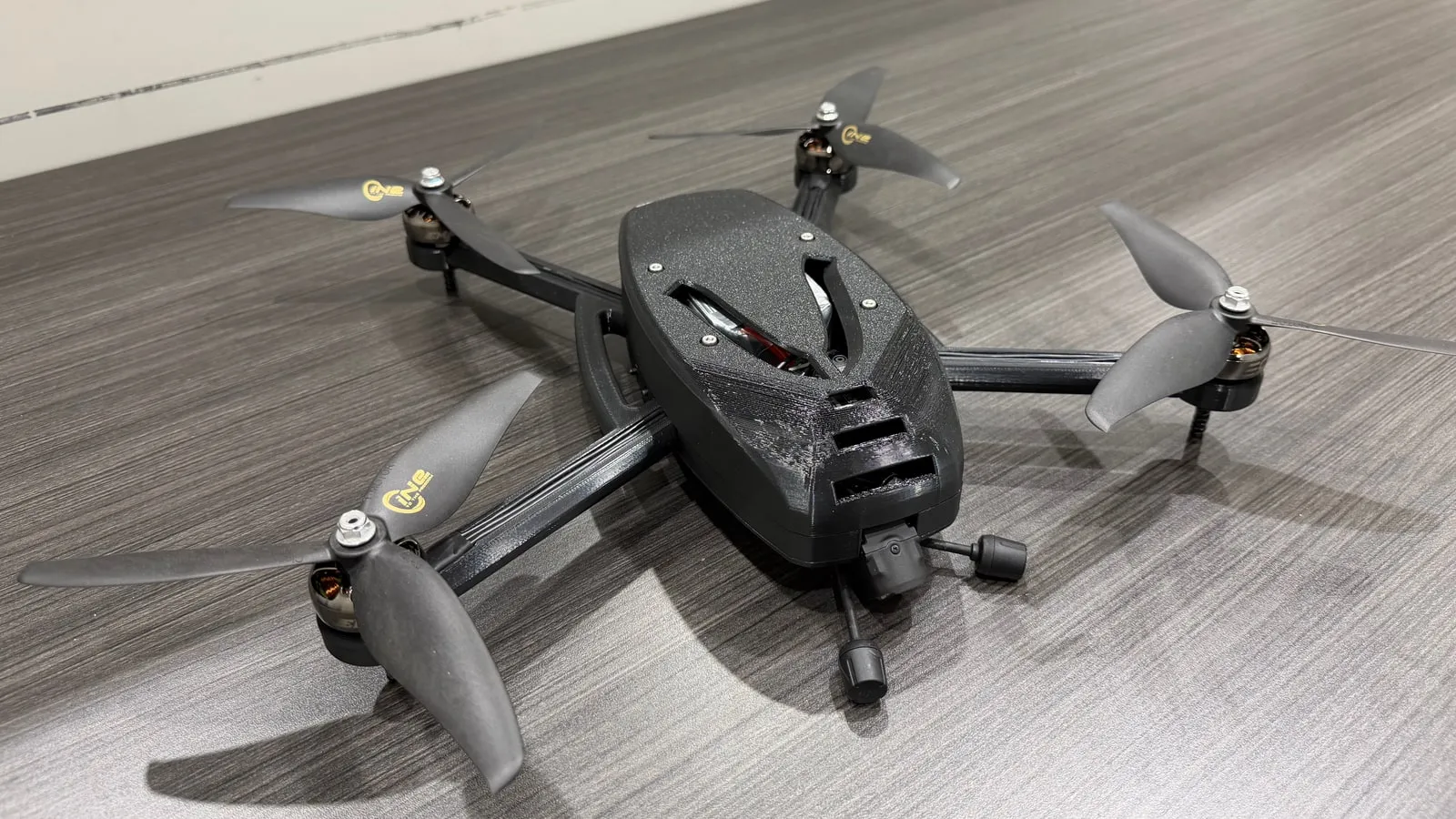 The finished v3 drone at a three-quarter angle, camera mounted and all four propellers on.