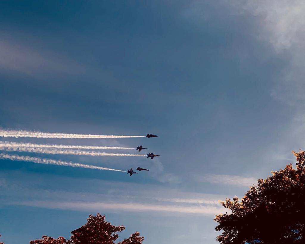 Jets trailing contrails across a blue sky.
