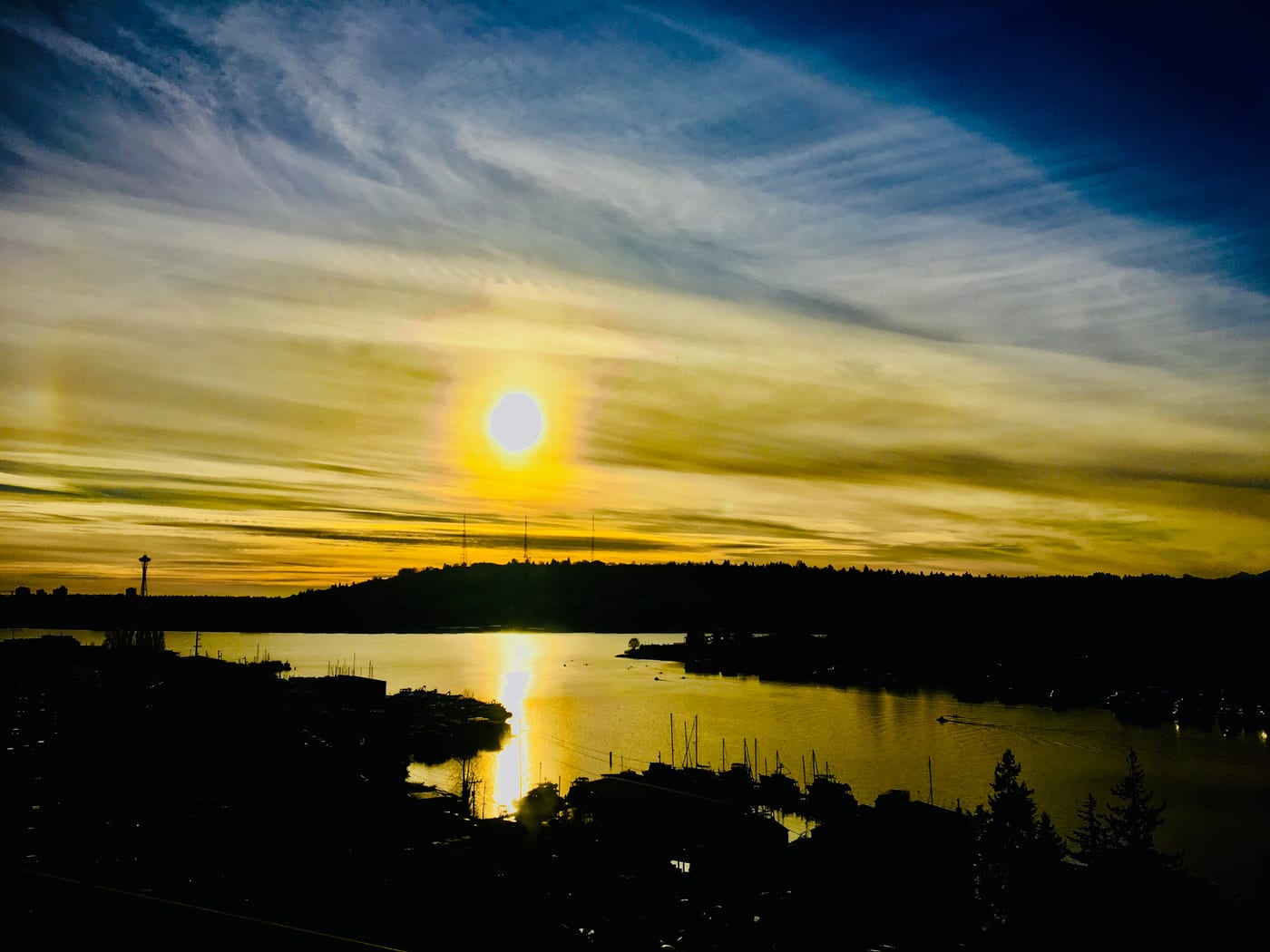 Sun setting over the water with the city beyond.
