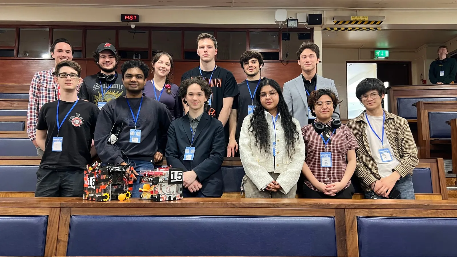 The Husky Robotics Society in a lecture hall at Unibots UK 2026, two competition robots on the bench.