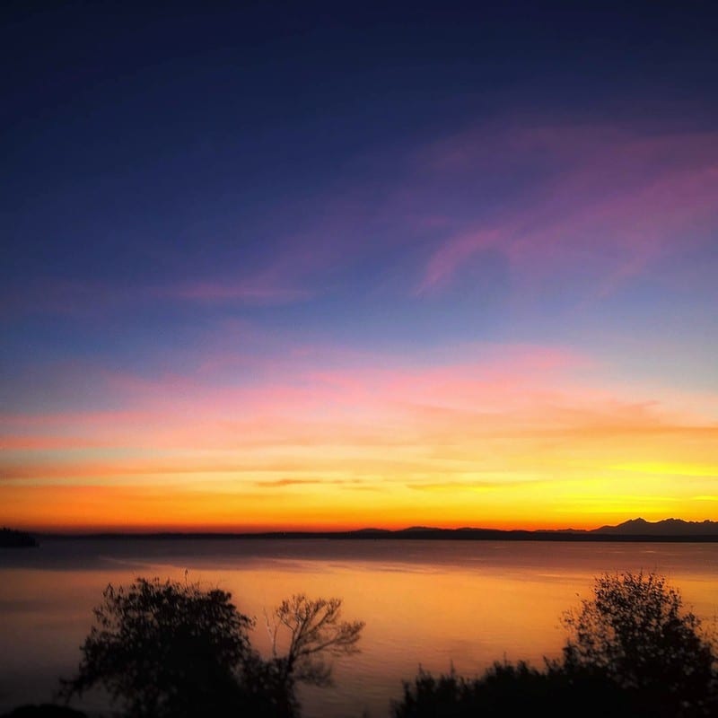 Layered sunset over calm water.