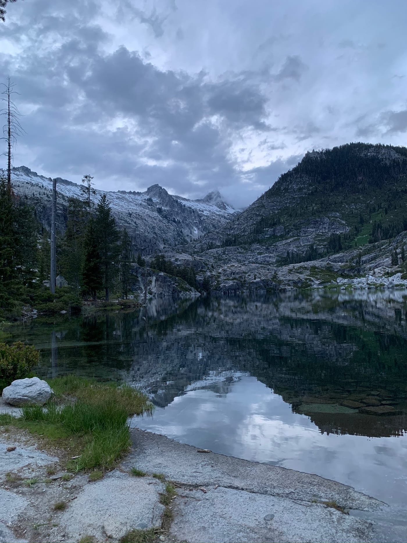 Snow-dusted peaks above a mirror-still lake.